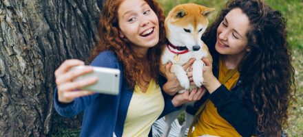 two teens taking a selfie with a dog outdoors: Bark vs Covenant Eyes: Which App is Best for You