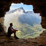 Guy sitting in a mountain cave opening, life after porn