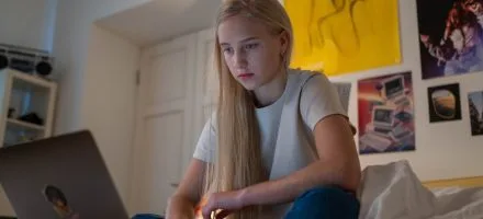 Girl on laptop in her bedroom internet safety tips